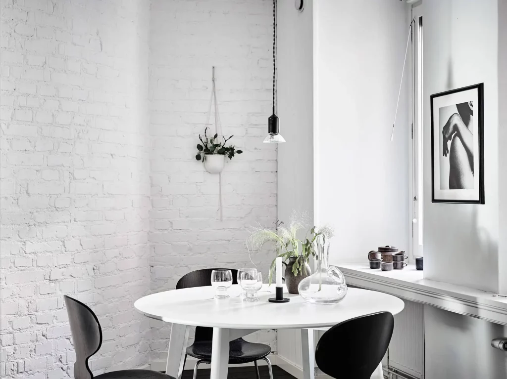 In deze keuken is een hangplant aan de witte stenen muur opgehangen - een leuke plek met indirect zonlicht.